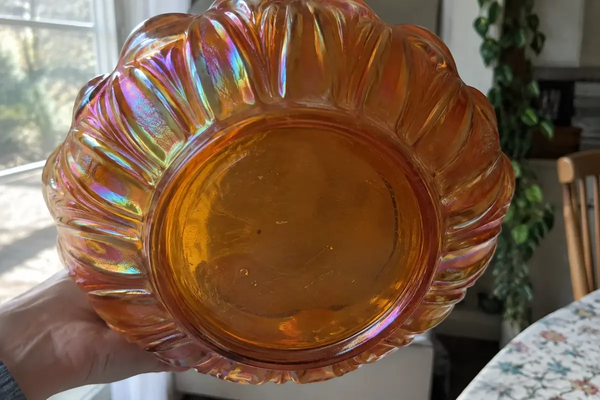 Underside of a marigold carnival glass bowl with a plain, non-shimmering base