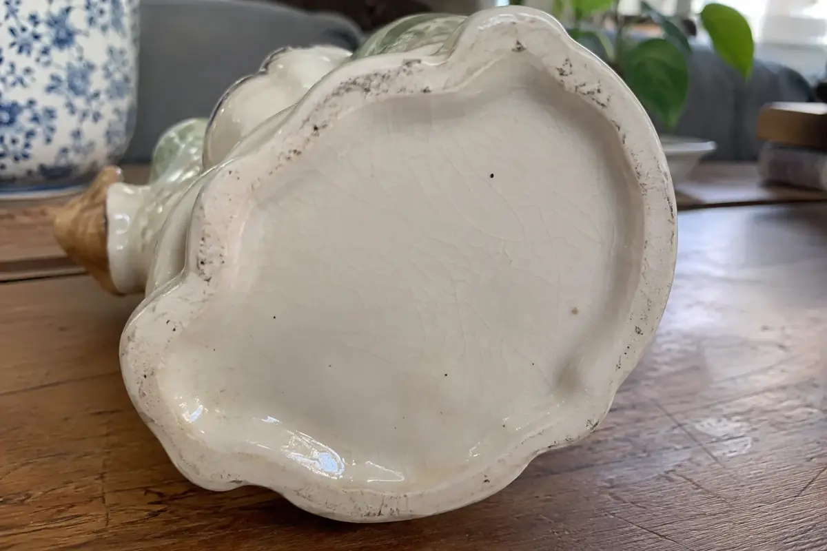 Underside of a porcelain figurine base showing the foot rim, glaze pooling and fine crazing